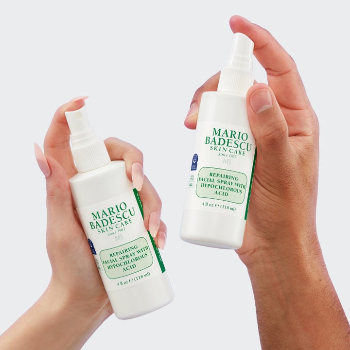 Mario Badescu Repairing Facial Spray 118 ml reparerende ansigtsspray i hvide flasker holdt af to hænder