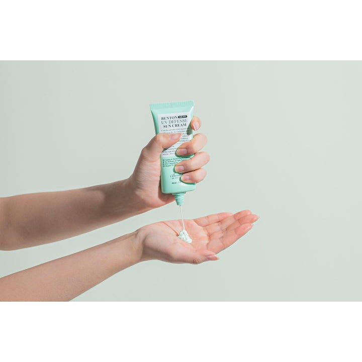 Benton Air Fit UV Defense Sun Cream 50 ml solcreme med SPF 50 der trykkes ud af en lysegrøn tube i hånden.
