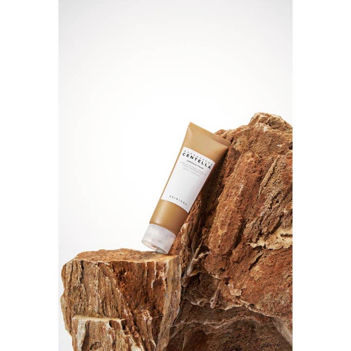 SKIN1004 Madagascar Centella Ampoule Foam 125 ml beroligende rengøringsskum i brun tube lænet mod en rå klippe