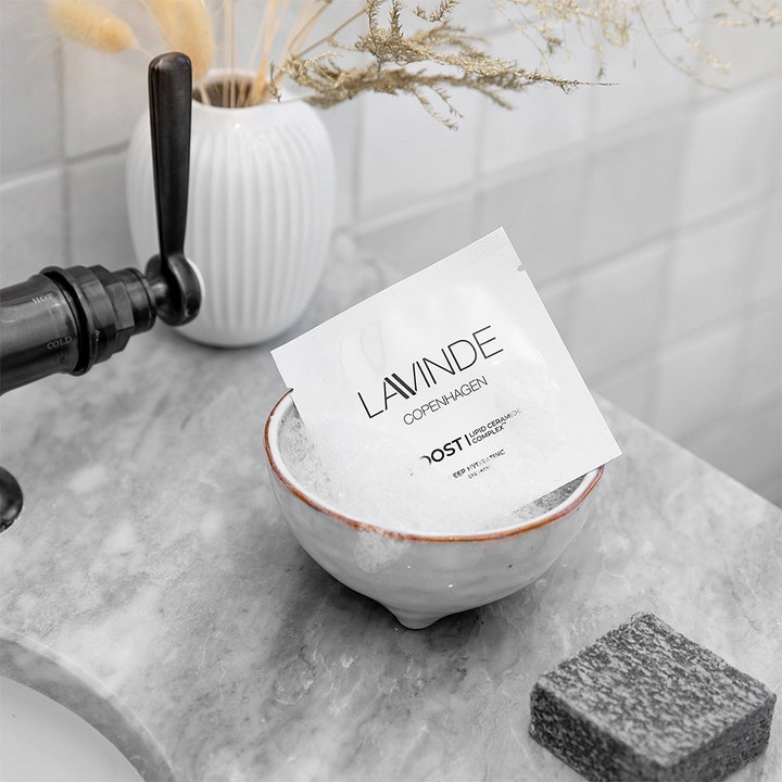 Lavinde Copenhagen Boost Deep Hydrating Eye Mask 2 stk fugtgivende eye patches i hvid sachet i en lille skål.