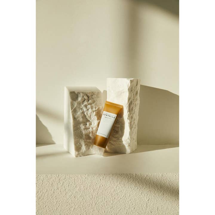 SKIN1004 Madagascar Centella Ampoule Foam 125 ml beroligende rengøringsskum i brun tube lænet mod hvide stenblokke
