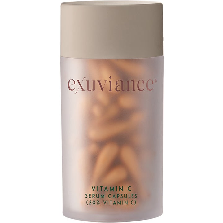 Exuviance Vitamin C Serum Capsules glødgivende serum i frostet krukke med beige låg og synlige orange kapsler
