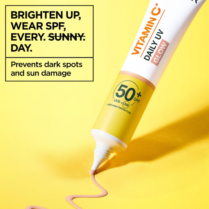 Garnier Skin Active Vitamin C Glow Boosting Daily UV Fluid 40 ml med SPF50+ påføres på to fingre for glød og beskyttelse.