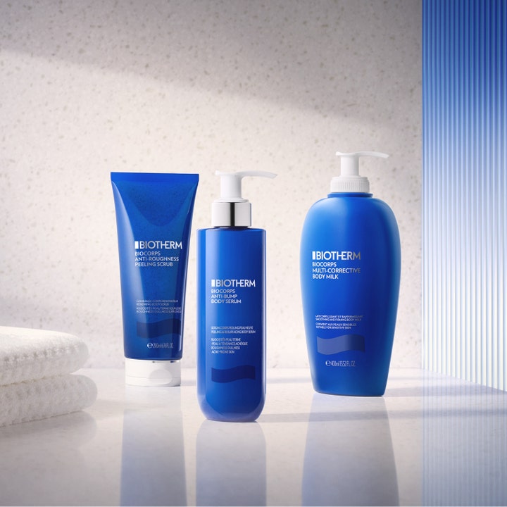 Biotherm Biocorps Multi-Corrective Body Milk 400 ml fugtgivende bodylotion i blå pumpeflaske ved hvide håndklæder