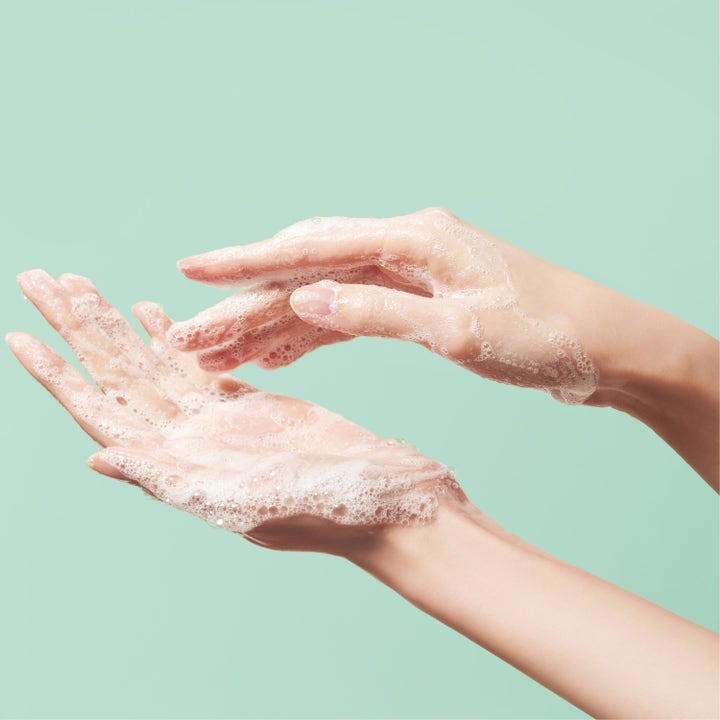 Make Prem Safe Me Oil To Foam Cleanser 200 ml rensolie danner et luftigt hvidt skum på hænderne mod en mintgrøn baggrund.