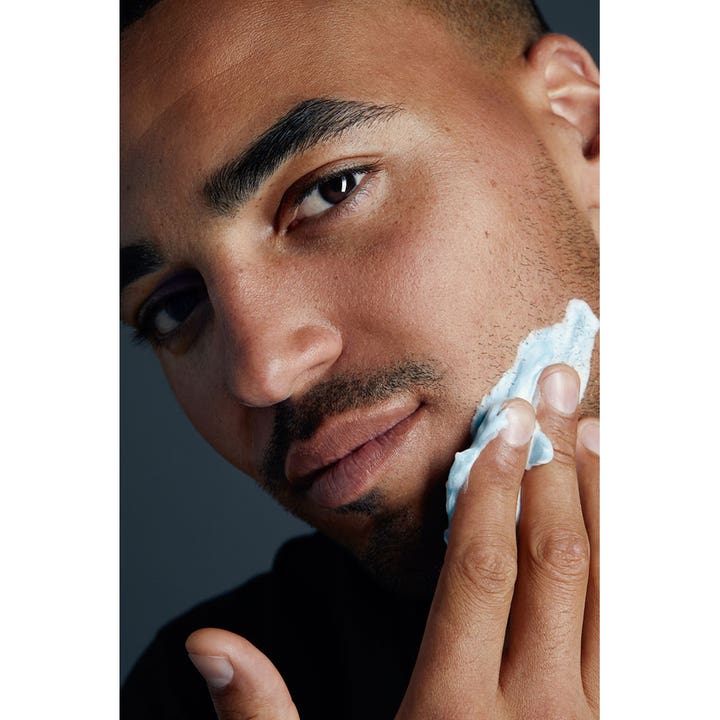 NIVEA Protect & Care Shaving Foam 200 ml beskytter huden mens en mand påfører hvidt barberskum på kinden.