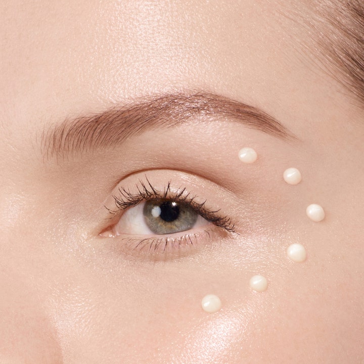 Lancôme Absolue The Eye Cream 20 ml øjencreme giver glød vist med små prikker påført omkring øjet