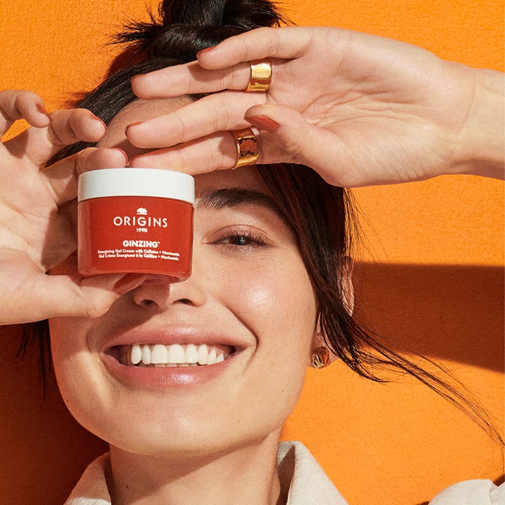 Origins Ginzing Energizing Gel Face Cream 30 ml holdes af smilende kvinde på orange baggrund