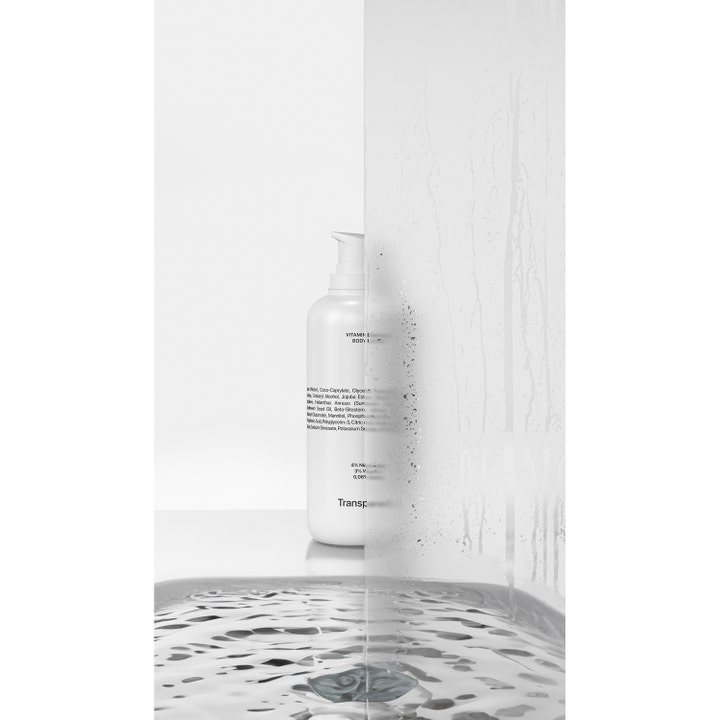 Niche Beauty Lab Transparent Lab Vitamin Enriched Body Lotion 400 ml fugter huden i hvid pumpeflaske bag vådt glas.