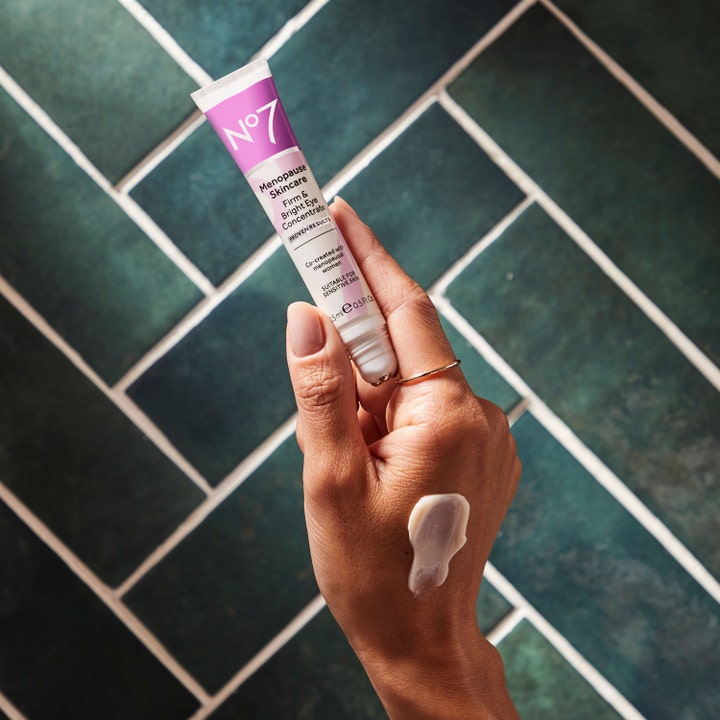 No7 Menopause Skincare Firm & Bright Eye Concentrate 15 ml øjencreme i hvid tube med cremet tekstur på en hånd