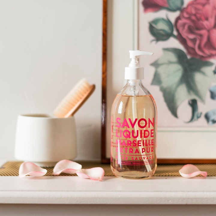 Compagnie de Provence Liquid Marseille Soap Wild Rose 495 ml i klar glasflaske med pumpe og dekorative rosenblade