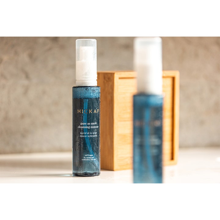 Hickap Pure As Snow Cleansing Mousse 150 ml fugtgivende ansigtsrens i blå gennemsigtig flaske foran en trækasse