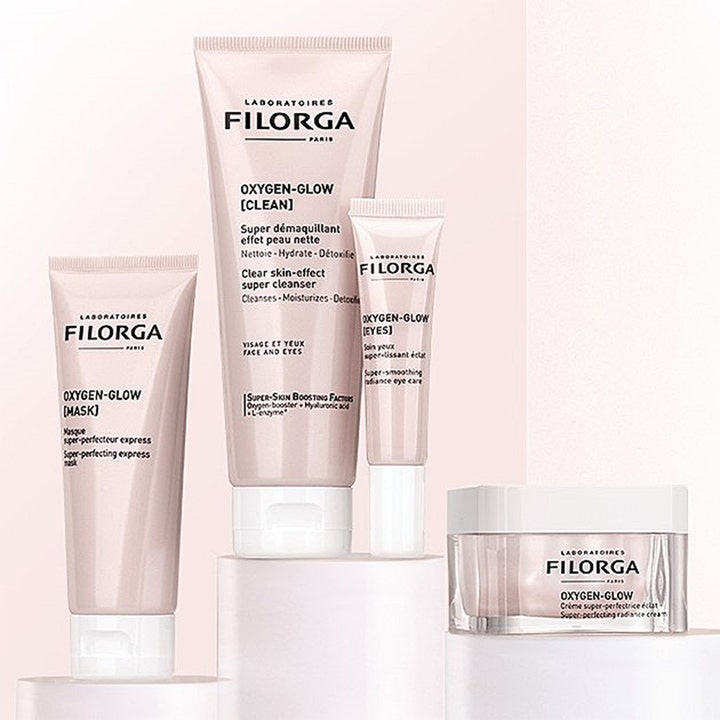 Filorga Oxygen-Glow Cream 50 ml fugtgivende dagcreme og hudplejeserie i lyserøde tuber og krukke på podier