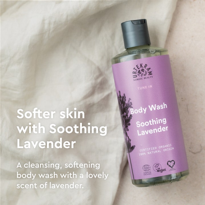 Urtekram Soothing Lavender Body Wash 500 ml beroligende kropsvask i lilla flaske på lyst stof giver blødere hud.