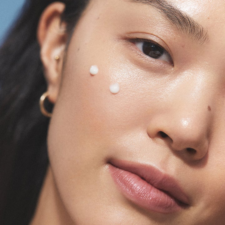 KORA Organics Plant Stem Cell Retinol Alternative Serum 10 ml ansigtsserum med to hvide dråber på en kind