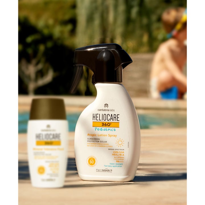 Heliocare Pediatrics Atopic Lotion Spray 250 ml solcreme med SPF 50 i hvid sprayflaske ved en solskinsrig pool