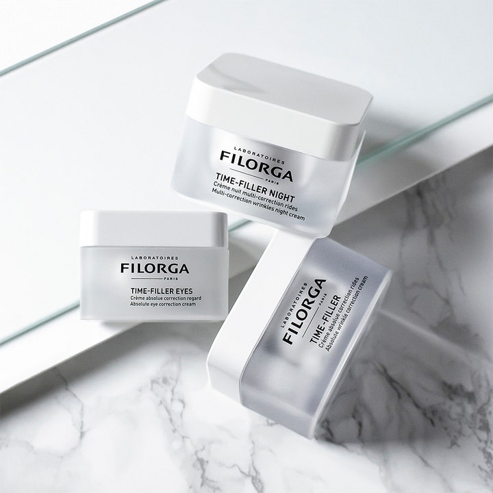 Filorga Time-Filler Night 5 XP 50 ml rynkekorrigerende natcreme i hvide krukker på en elegant marmorbund.