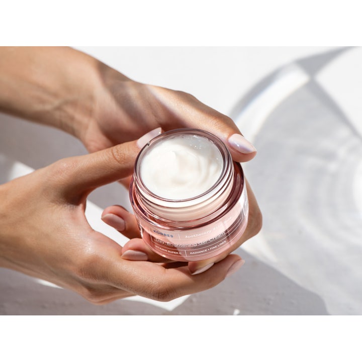 KORRES Apothecary Wild Rose Day-Brightening Gel-Cream 40 ml ansigtscreme giver glød i lyserød krukke holdt i hænderne