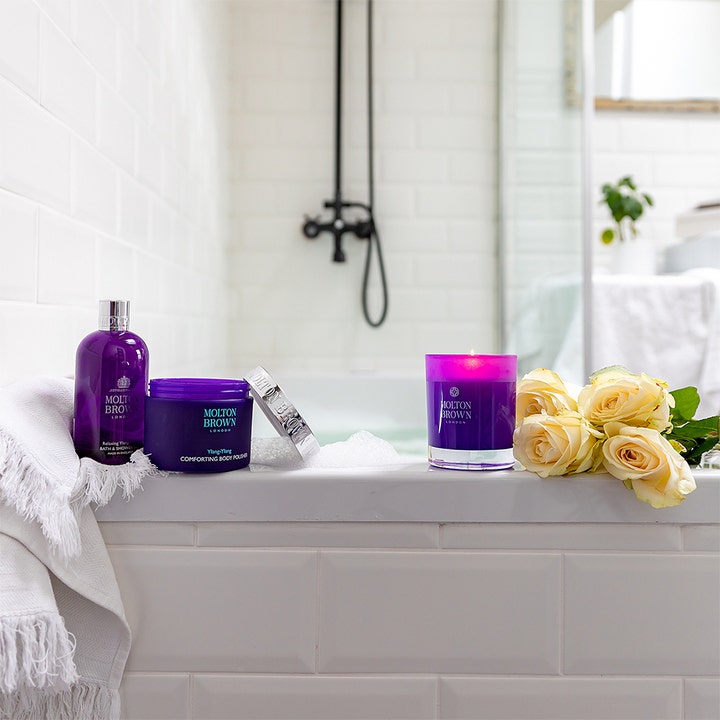 Molton Brown Relaxing Ylang Ylang Bath & Shower Gel 300 ml beroligende kropspleje i et lyst badeværelse med hvide roser.