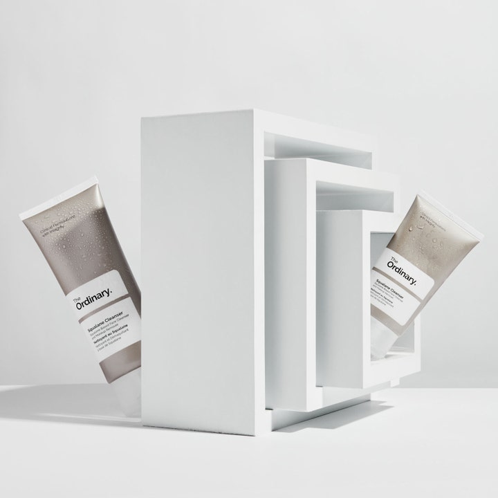 The Ordinary Squalane Cleanser 150 ml fugtgivende ansigtsrens i hvide tuber med vanddråber ved hvide blokke