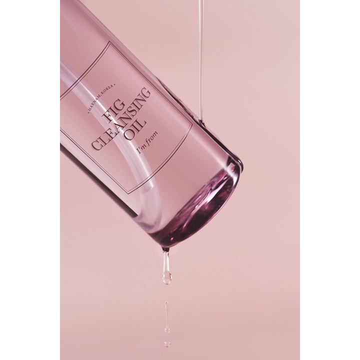 I'm from Fig Cleansing Oil 200 ml rensende ansigtsolie i en gennemsigtig flaske der drypper mod en rosa baggrund.