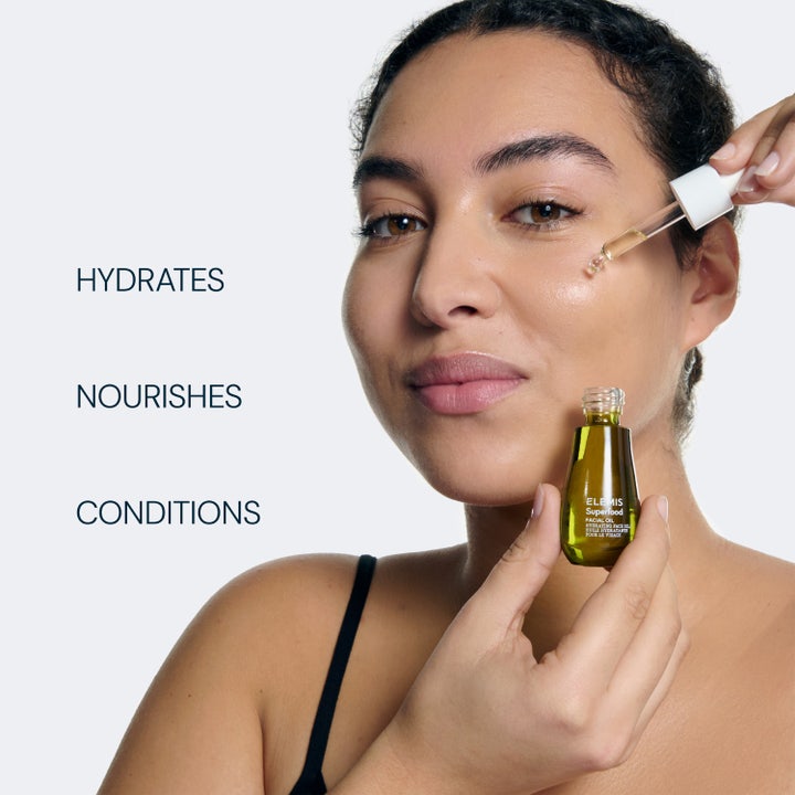 Elemis Superfood Facial Oil 15 ml ansigtsolie påføres med pipette på en kvindes ansigt for glød.