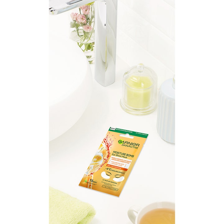 Garnier Skin Active Eye Tissue Mask 1 stk fugtgivende øjenmaske i orange sachet vist i et lyst badeværelse