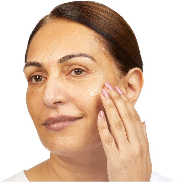 No7 Restore & Renew Multi Action Face & Neck Serum 30 ml giver fasthed mens en kvinde påfører serum på sin kind